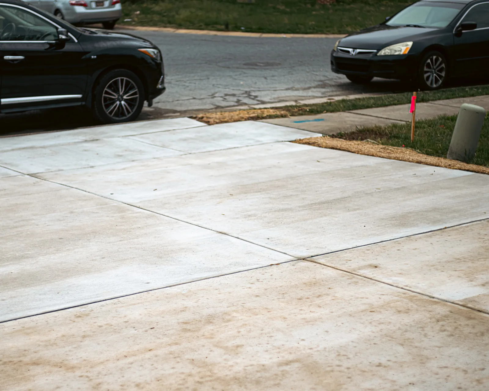 Completed concrete driveway with parked car in New Castle County, DE