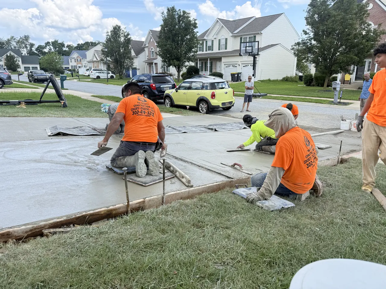 Crew finishing a freshly poured concrete driveway in New Castle County, DE