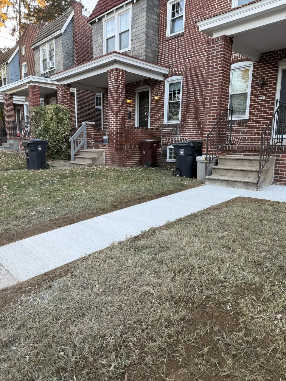 New concrete sidewalk in front of brick rowhomes in Wilmington, DE
