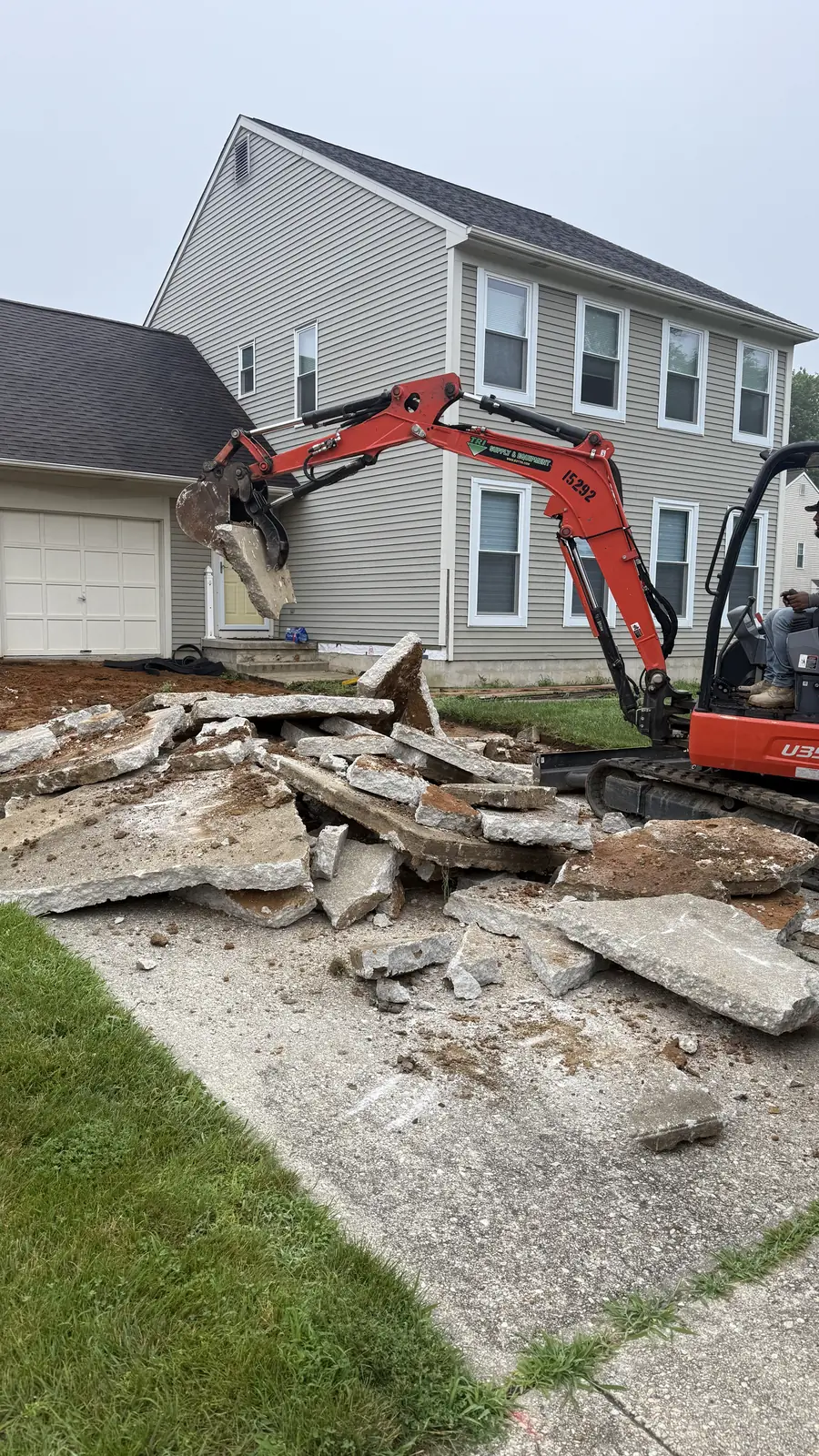Excavator breaking up old concrete during demolition in New Castle County, DE