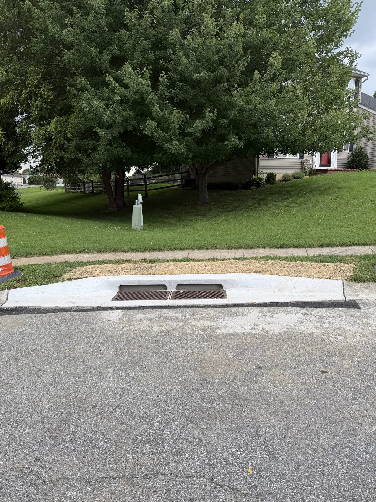 New concrete storm drain inlet and curb section poured along a residential street in New Castle County, DE