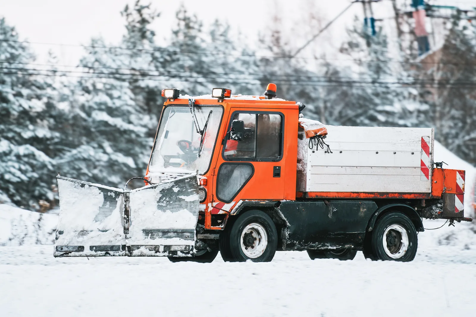 Snow plow truck clearing a paved driveway during winter in New Castle County, DE